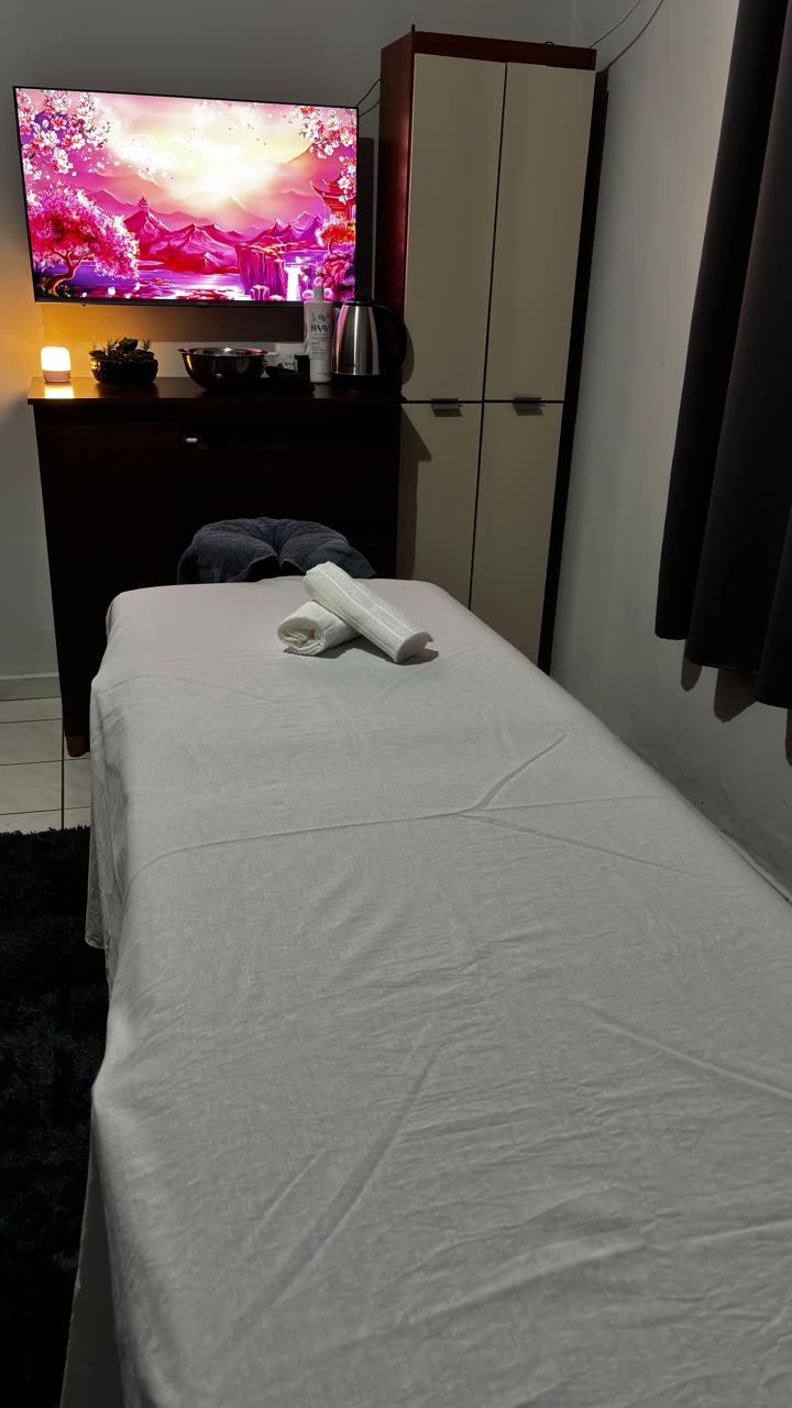 Sala de atendimento de Erick Leite Neves Guerrino, com maca preparada e ambiente em luz baixa